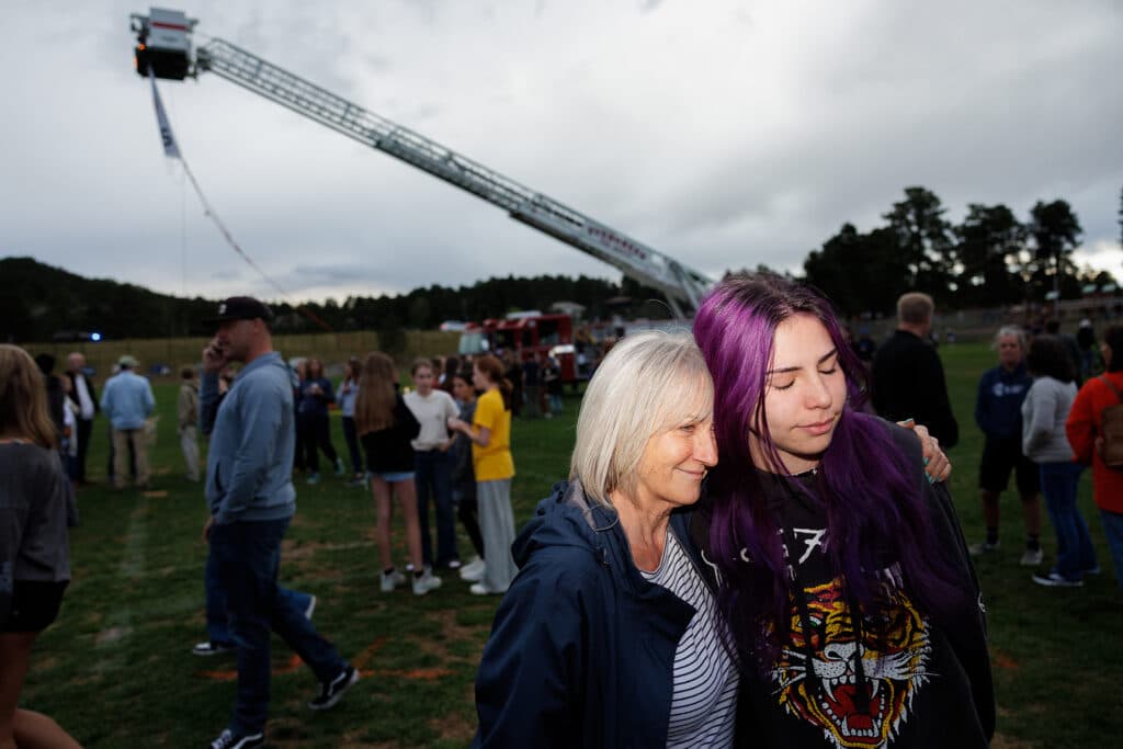 Wendy Moore hugs her niece, Aspyn Wyant, at a vigil