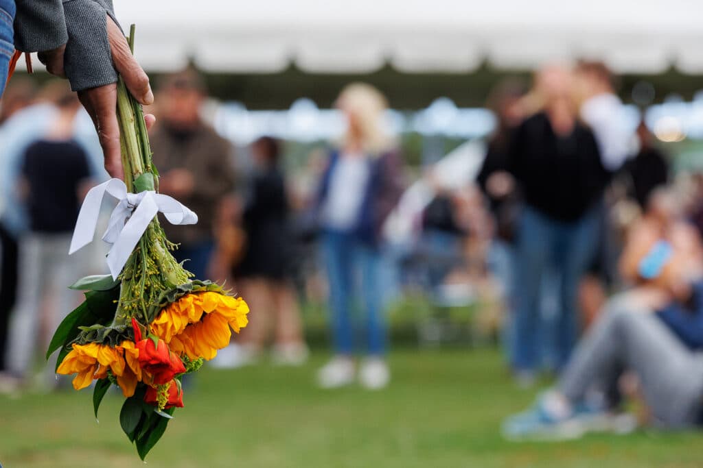 An attendee at the vigil holds flowers at a vigil