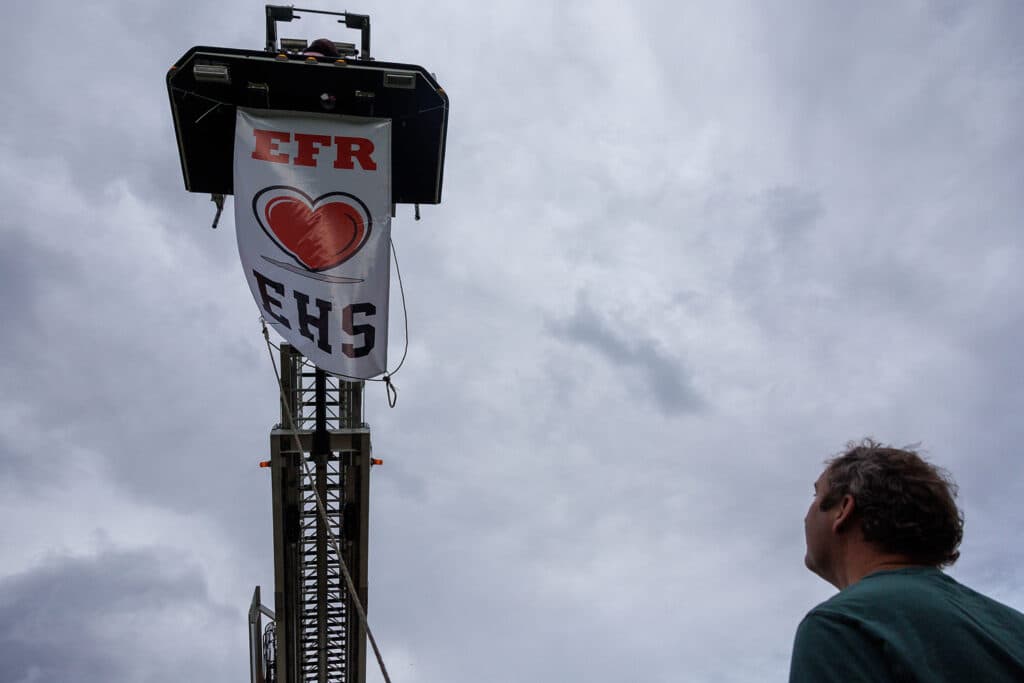 Evergreen Fire and Rescue hangs a banner from a ladder