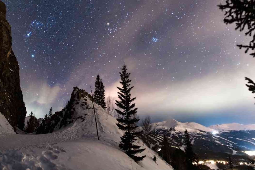 Stars in a night sky over the mountains.