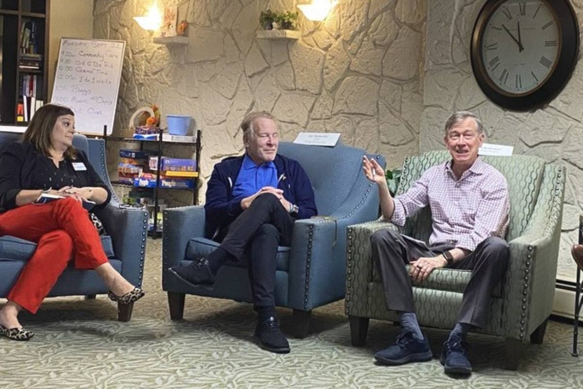 Three people, two men and one woman, are sitting in arm chairs.