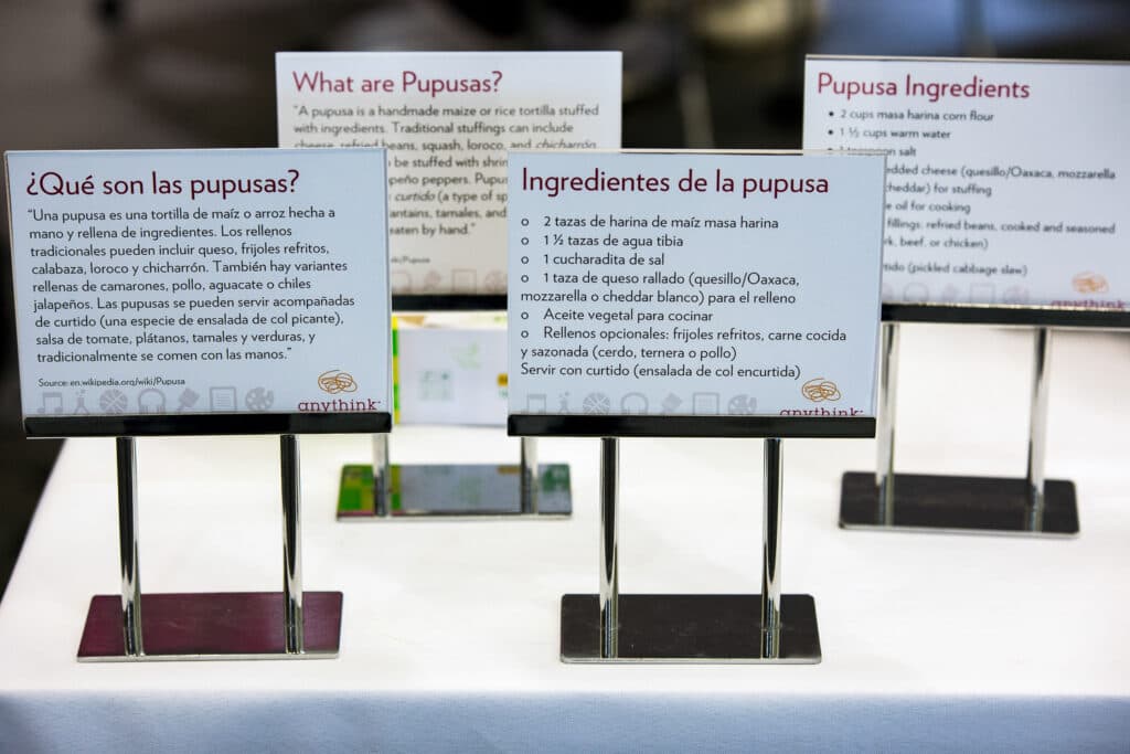 Placards explaining pupasas and detailing pupusa-making ingredients stand on a table.