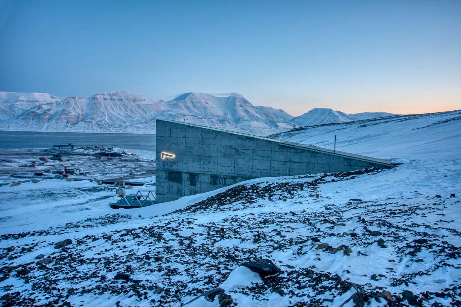 A concrete building built in the side of a snowy mountain.