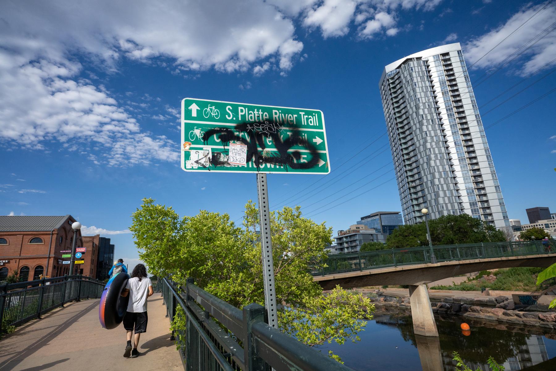 Graffiti and stickers blot out bike path directions at Denver's Confluence Park