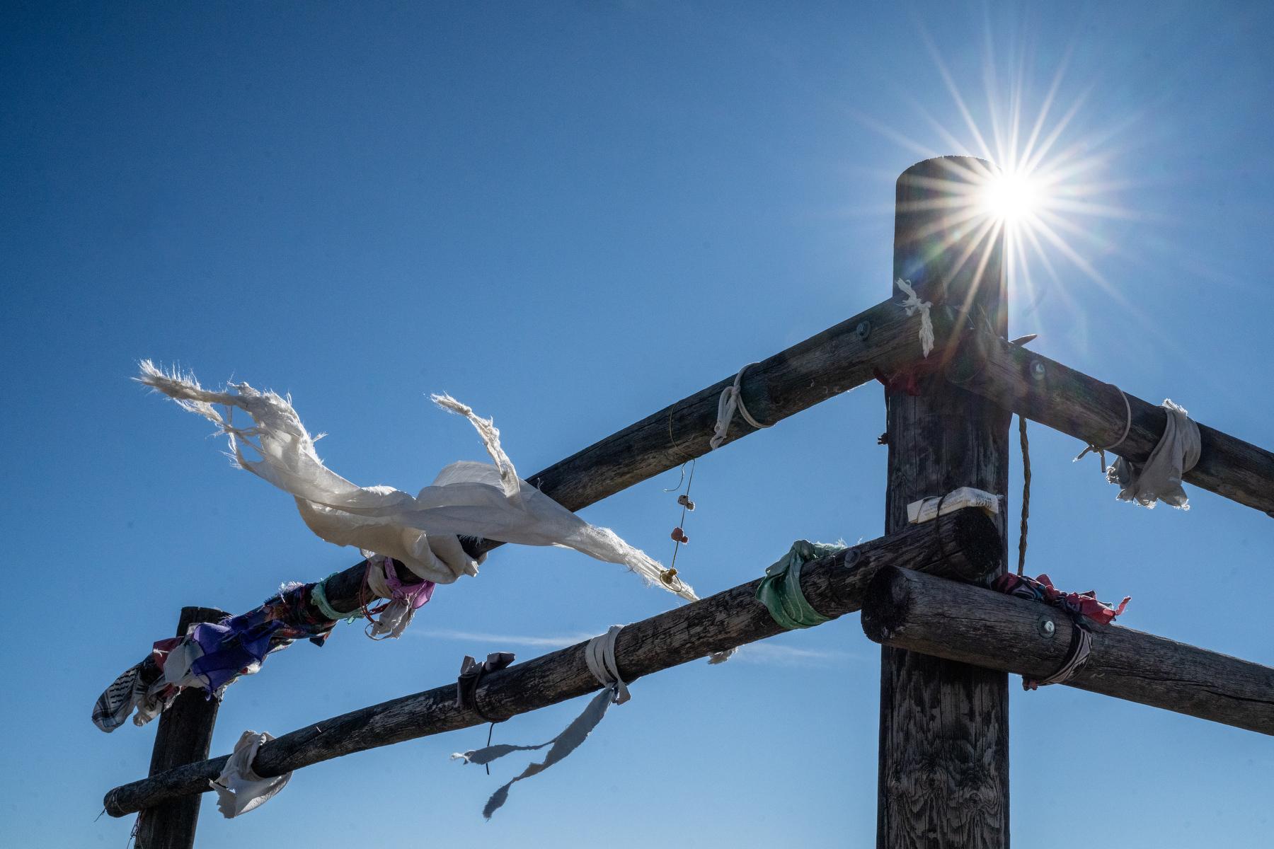 Beads, necklaces, bracelets and pieces of fabric blow in a cold winter wind on a fence