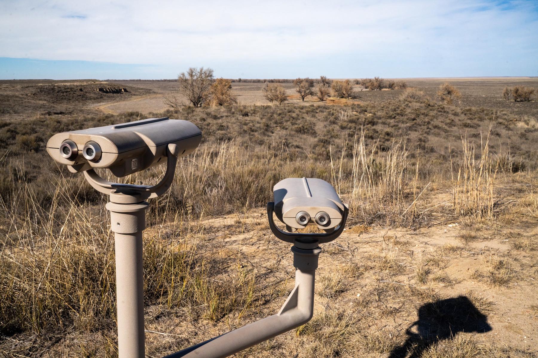 Tower viewers overlook a dirt field