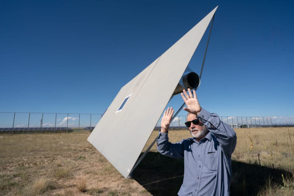 Hank Price of Solar Dynamics in front of a heliostat