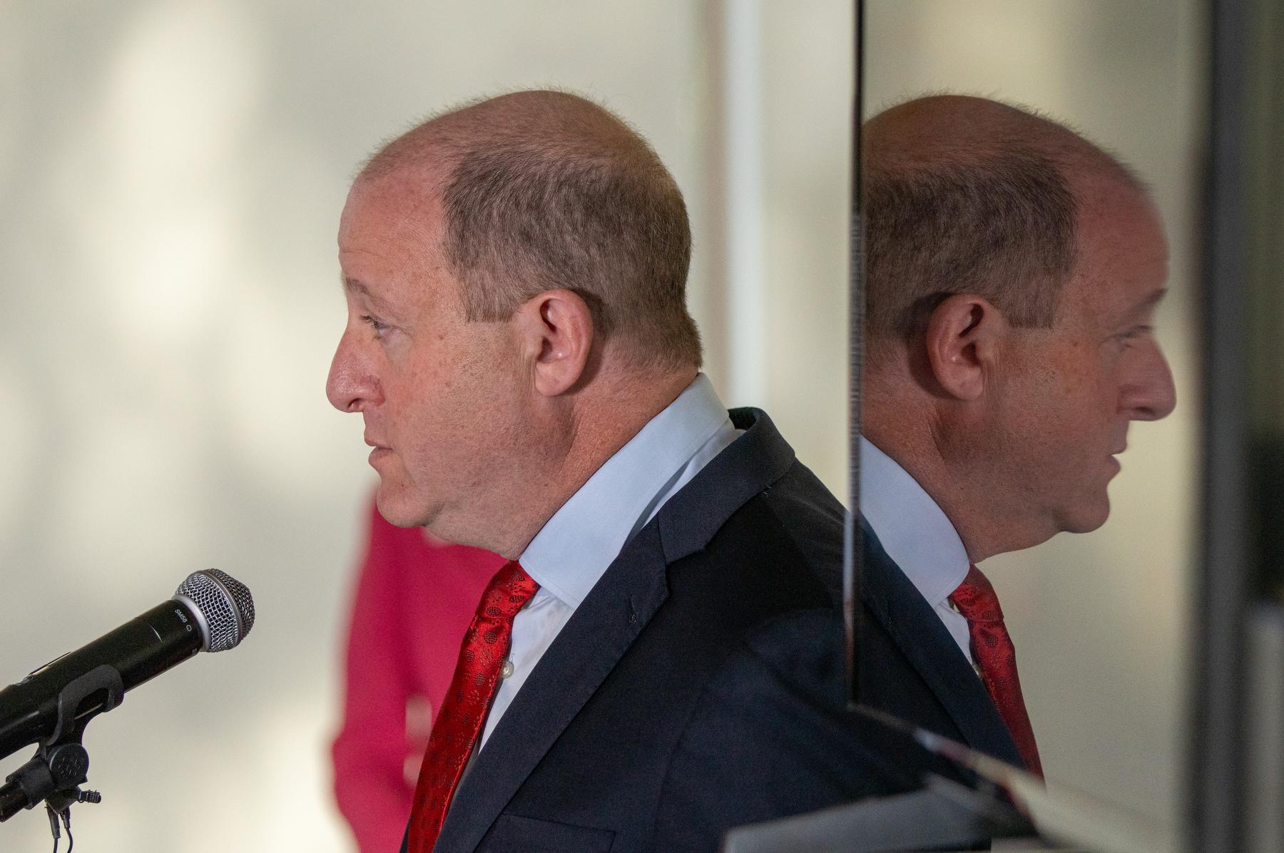 Colorado Governor Jared Polis speaks at a microphone