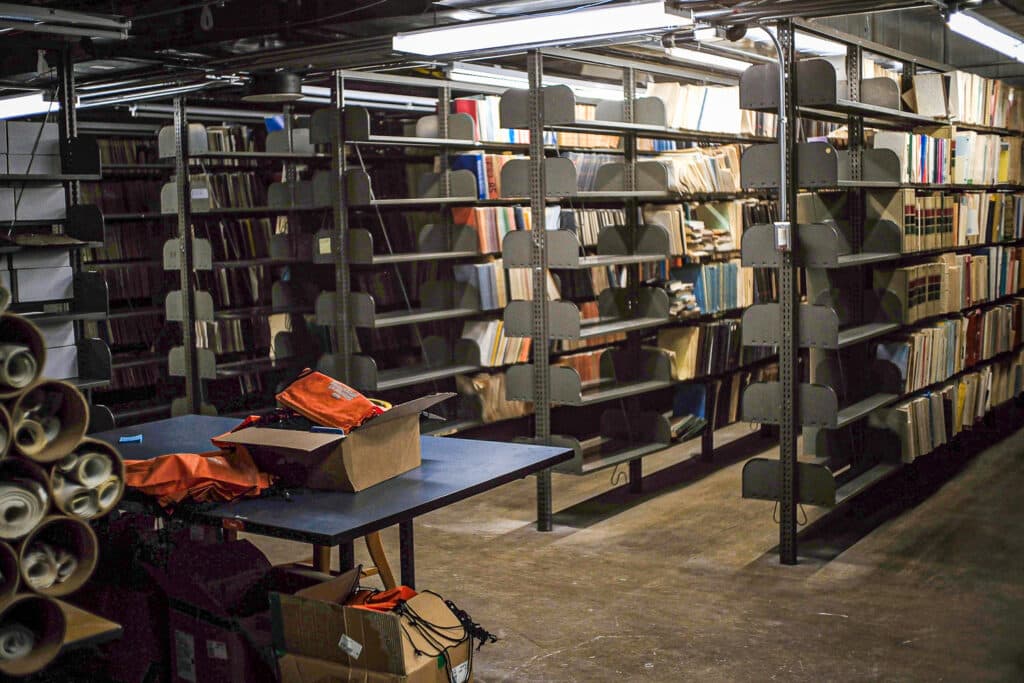 picture of shelves filled with books and documents in a dark basement