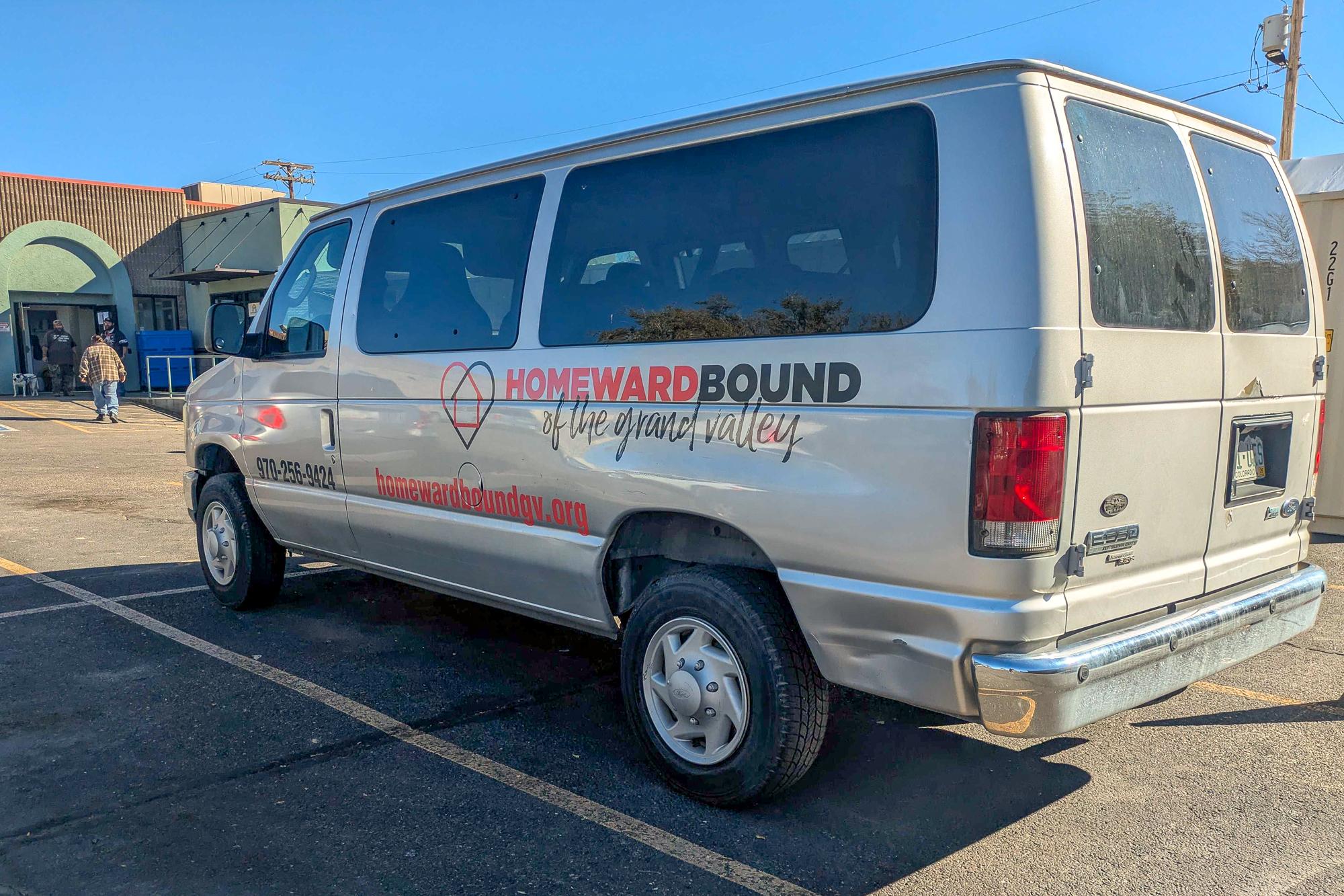 A gray ford passenger van sits outside of HomewardBound of the Grand Valley's North Avenue location