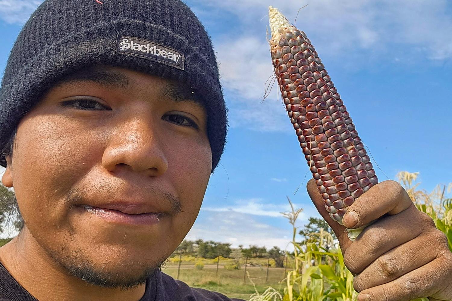TeAndre McLane holds an ear of blue corn