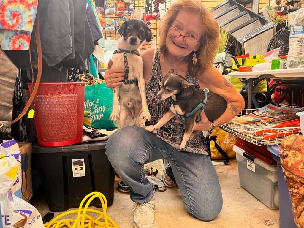 Woman kneeling while holding two dogs