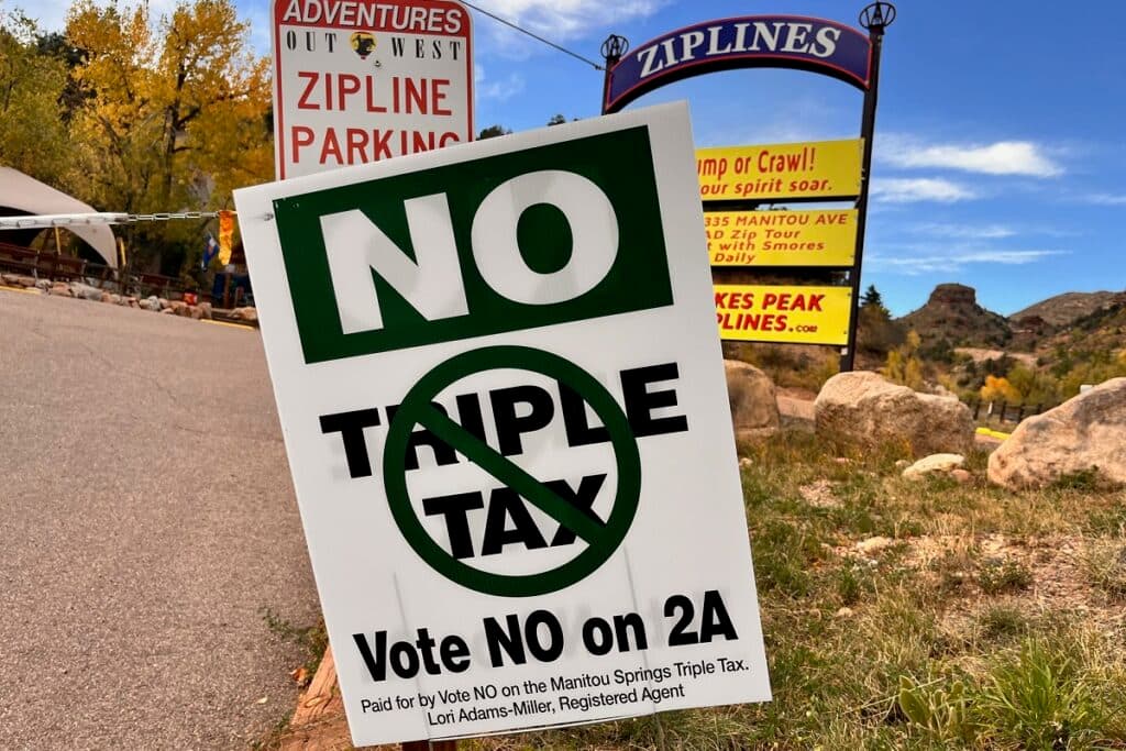 A sign is posted on a sidewalk.