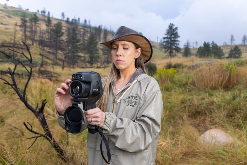 Image shows researcher with camera outdoors