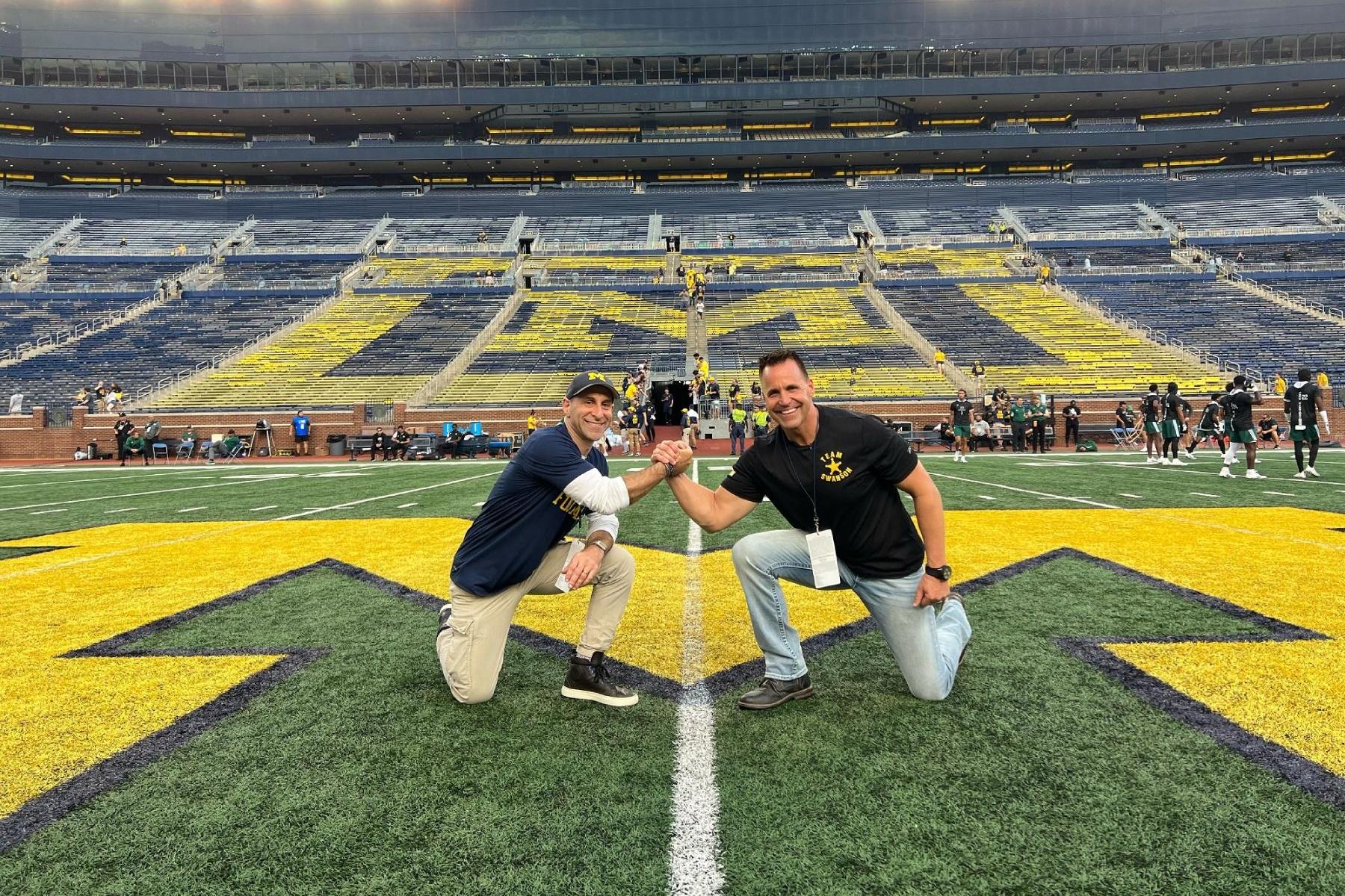 Two man kneeling on football field