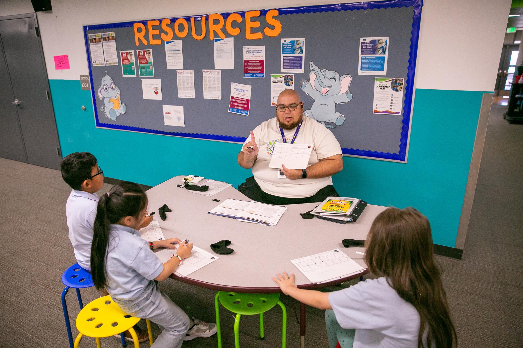 Reading tutor Gabe Martinez with a student work group