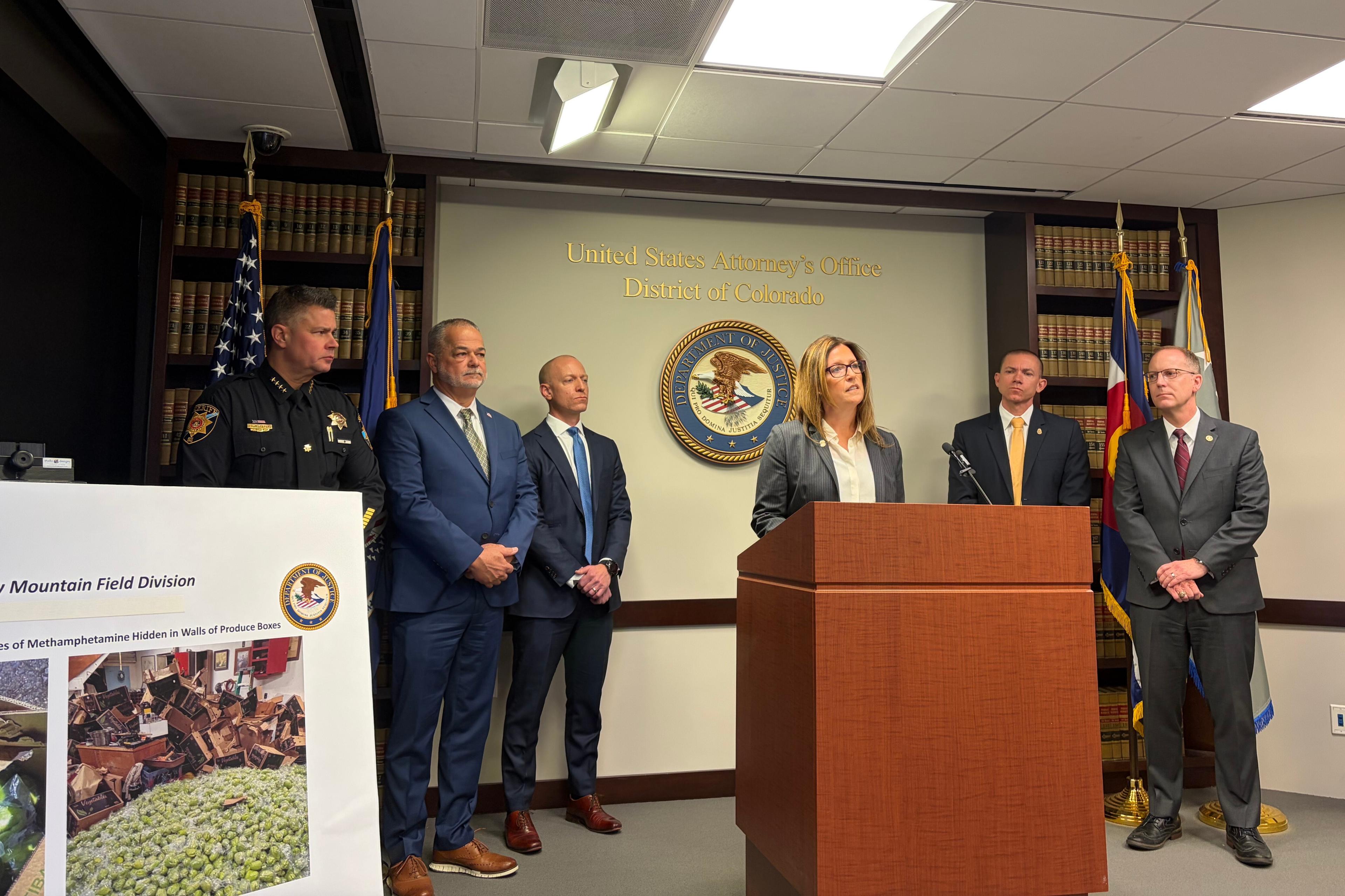 The image features a group of six people standing in front of a wall with a logo.