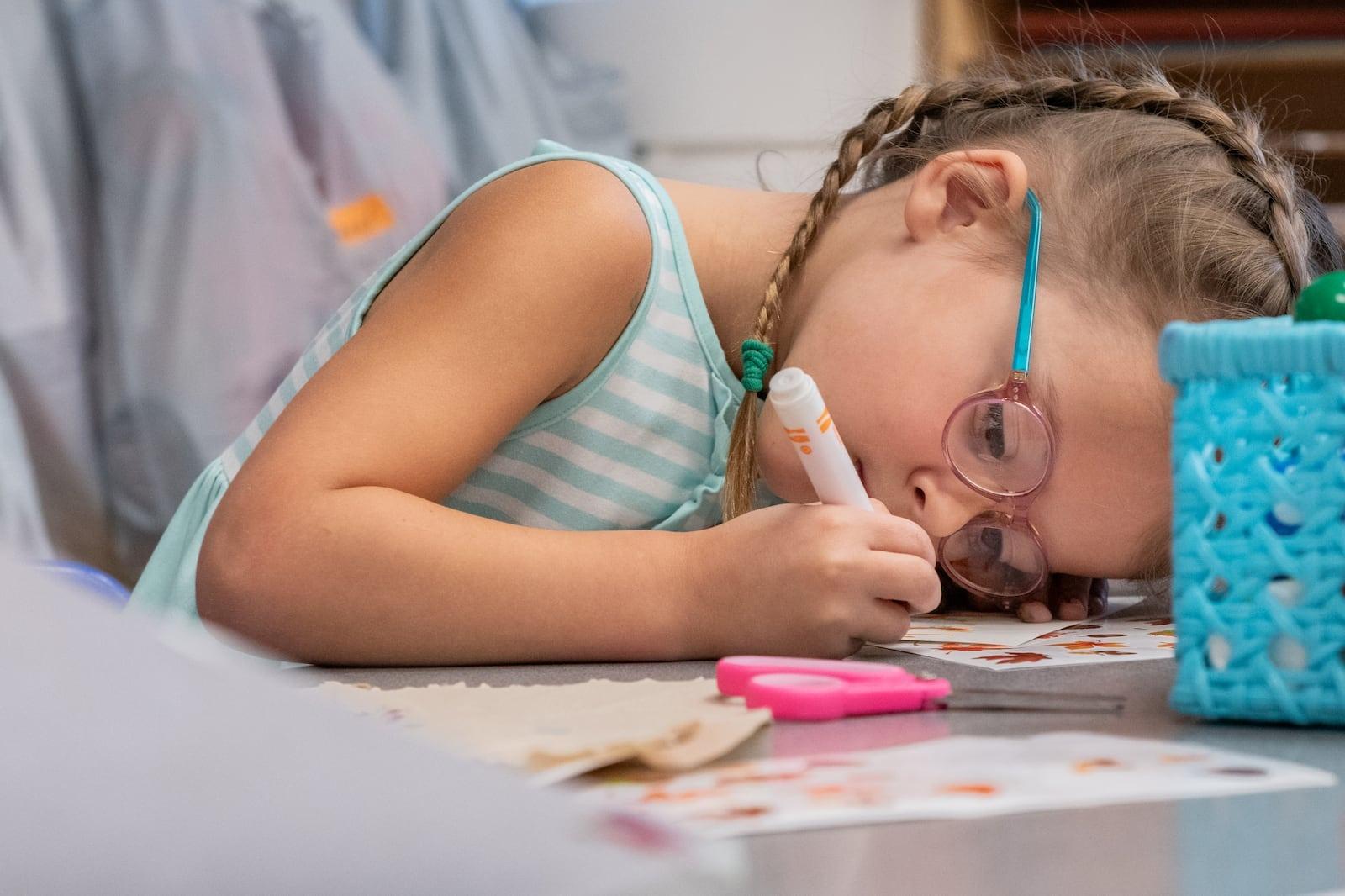 A child colors on a table