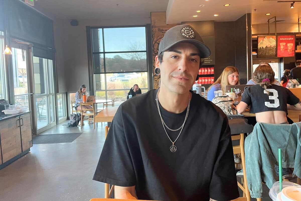 A person sitting down poses for the camera