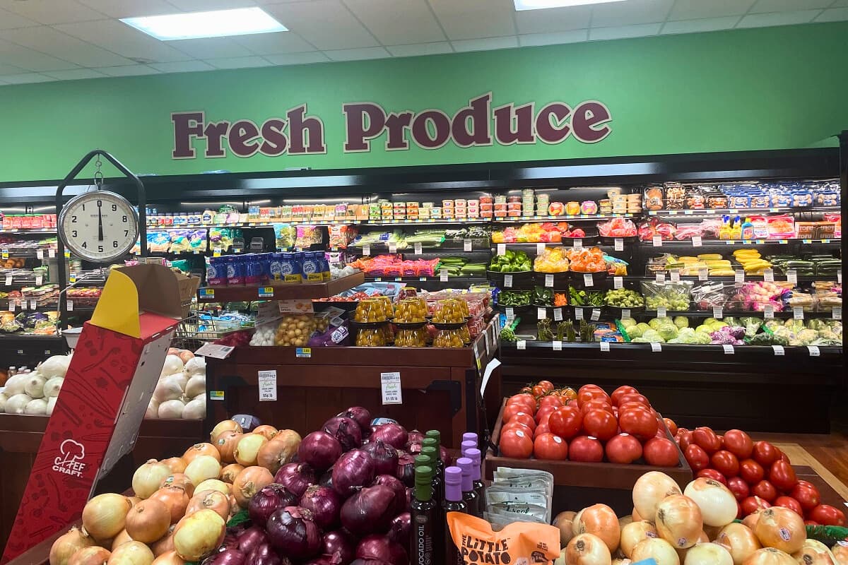 A sign that says fresh produce on a wall inside a store