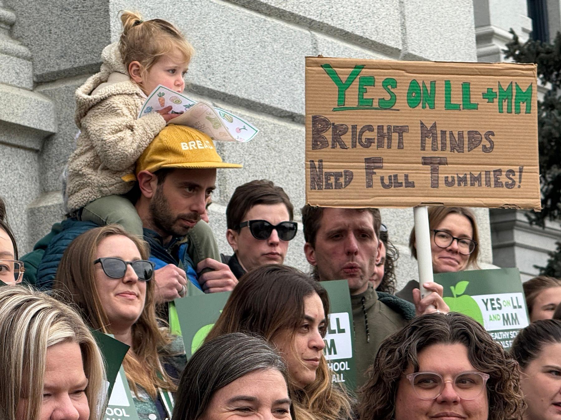 People stand holding signs.