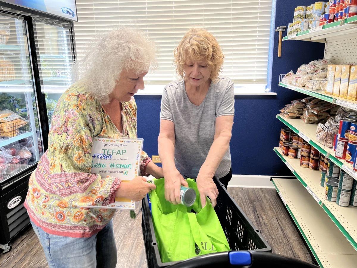 Two people standing over a grocery cart