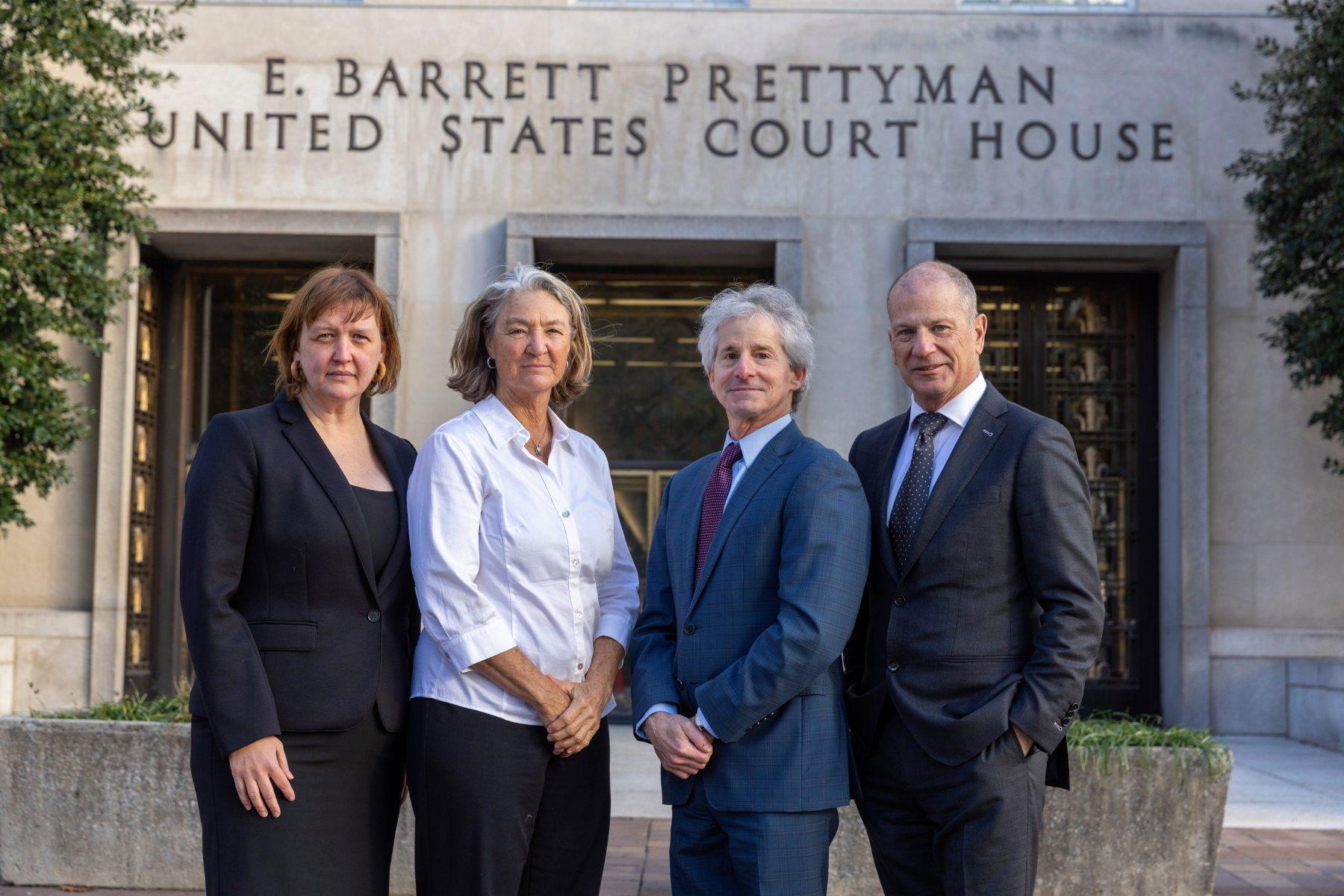 Two women and two men stand in front of the E. Barrett Prettuman US Court House