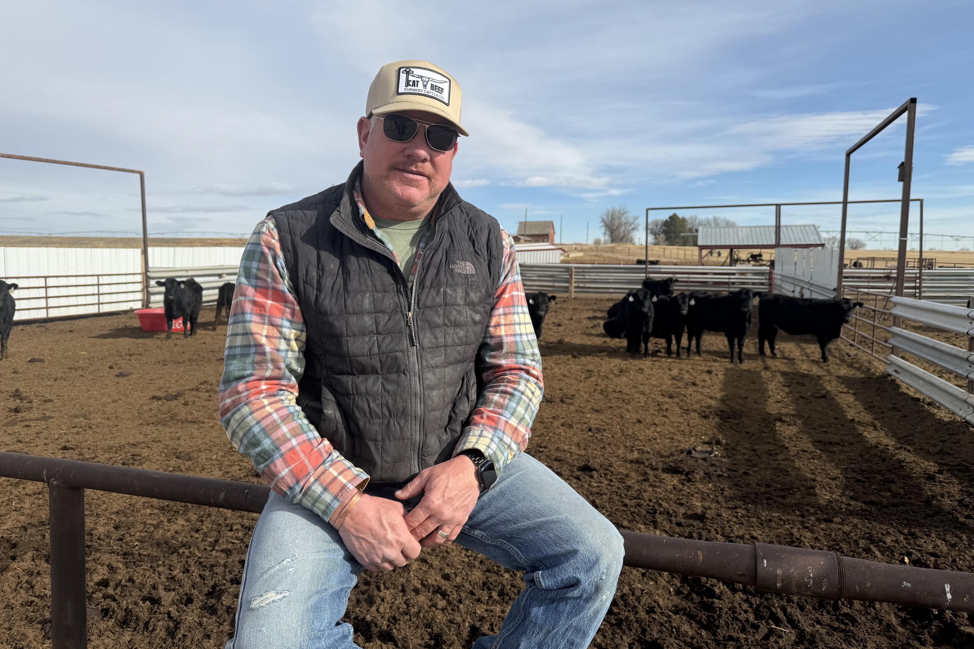 Chad Sanger, 50, sits on the fence of cattle pen at his ranch, Turnkey Cattle Company, outside of Greeley, CO, on Tuesday, December 2, 2025. Sanger said he is frustrated by the Trump administration's decisions around beef imports.