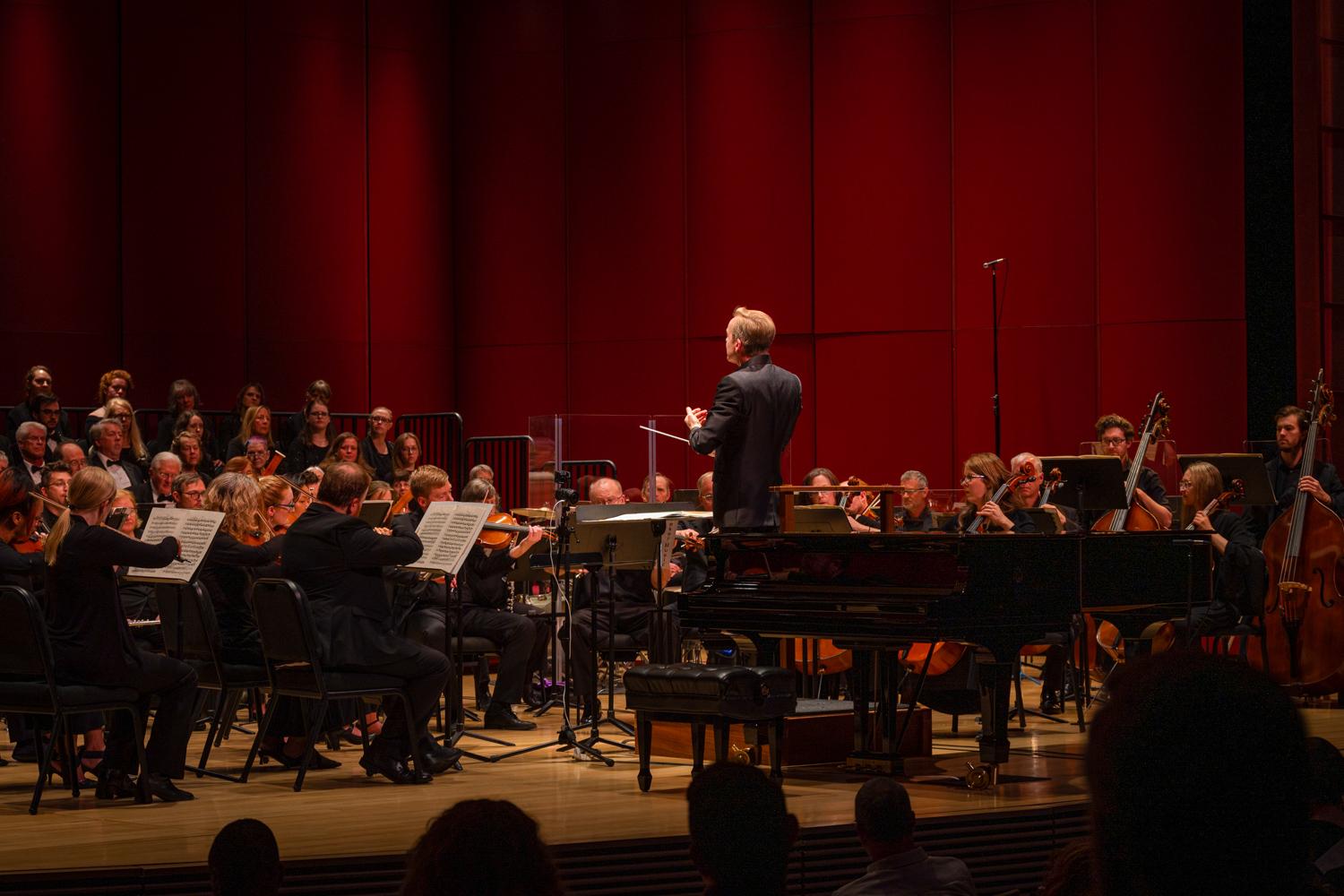 orchestra musicians and conductor on a stage