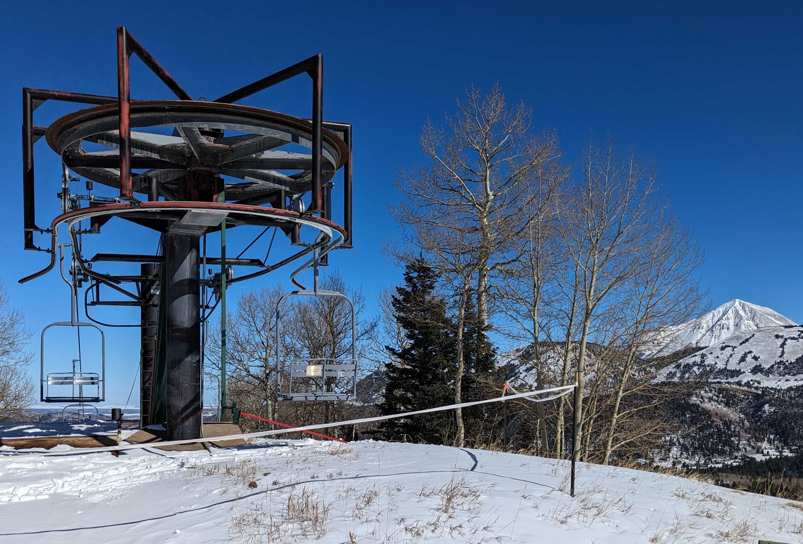 the top of a ski chairlift with mountain peaks in the background