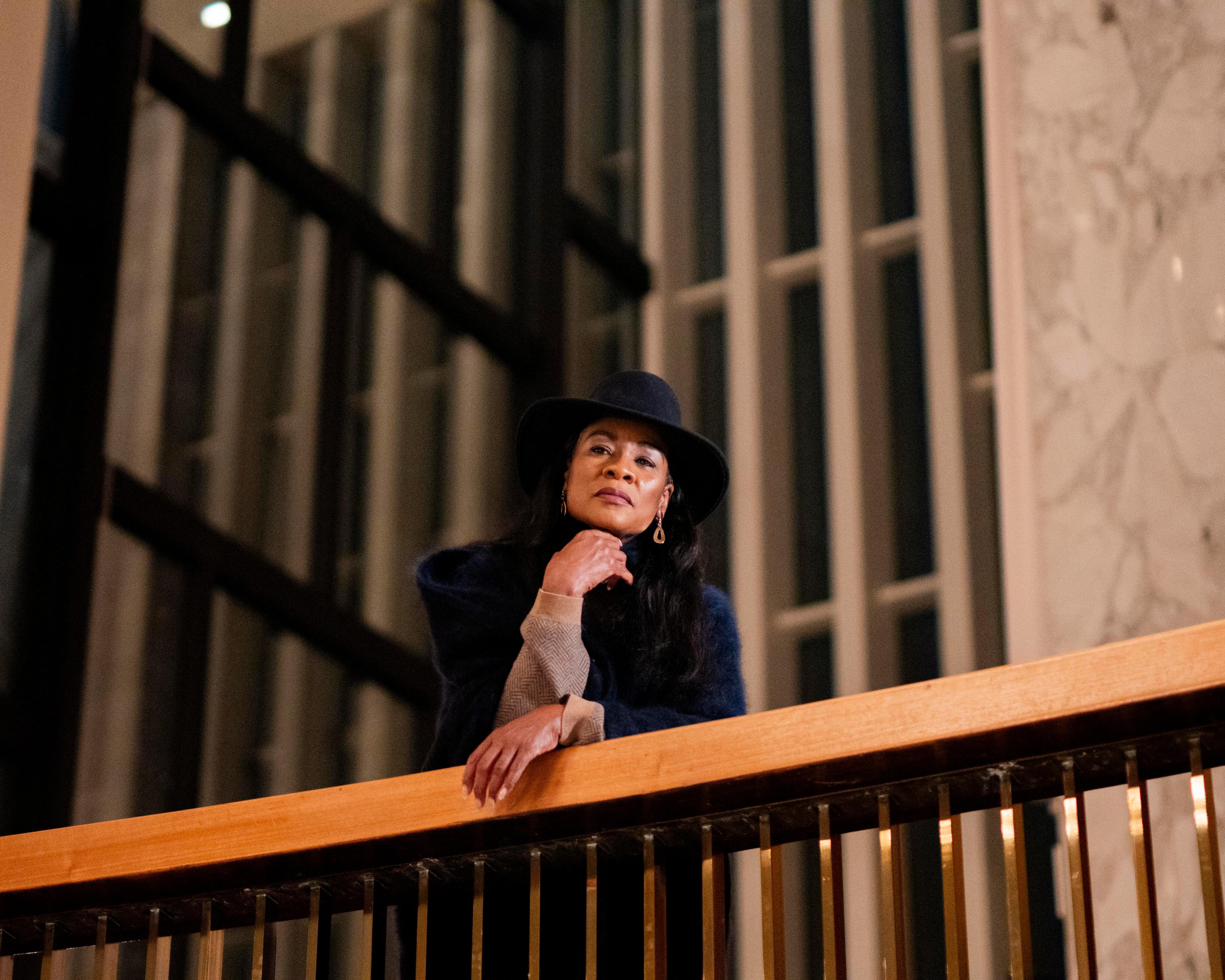 Woman in black hat overlooks a railing
