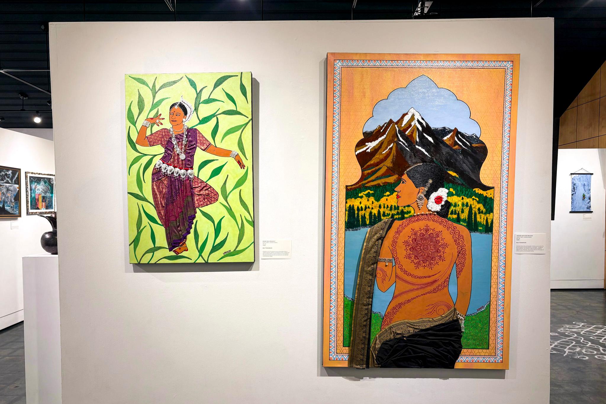 Two paintings depicting brown-skinned women draped in flowing fabric hang on a white wall.