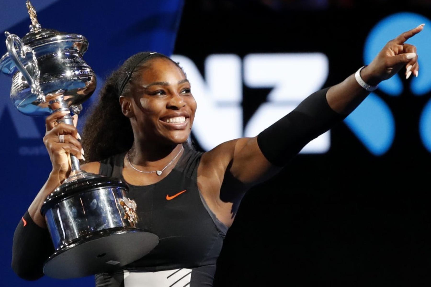 a woman holds a trophy and points off camera smiling